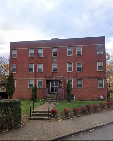 a view of a brick building next to a yard