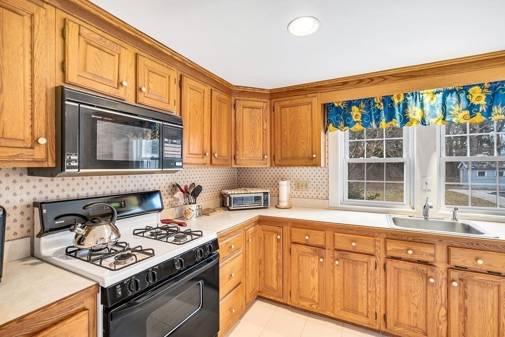 105 Hartford Street Natick, MA 01760 - Photo 16 of 41 a kitchen with stainless steel appliances granite countertop a stove a sink and a microwave