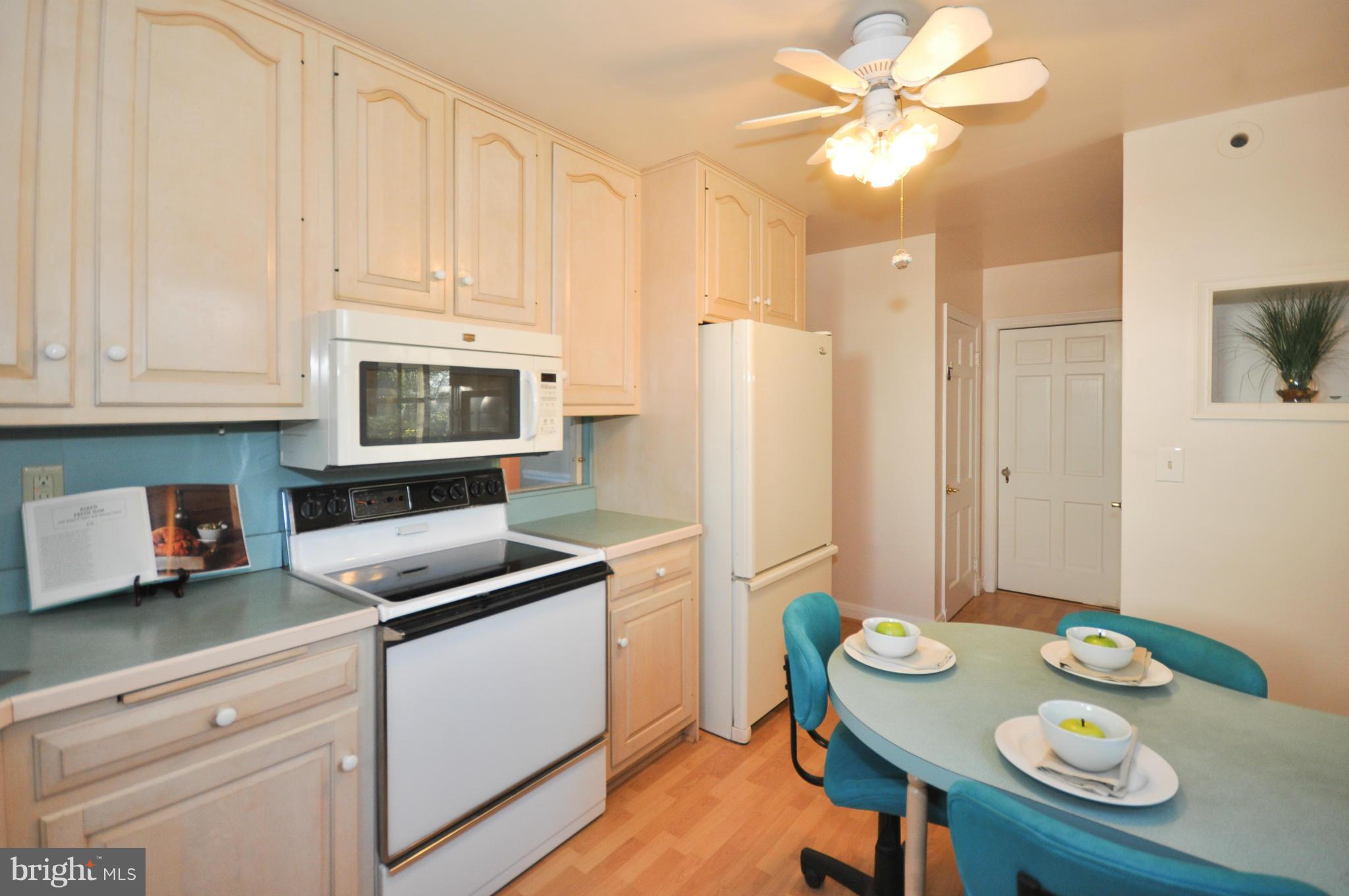 409 Aigburth Road Baltimore, MD 21286 - Photo 13 of 27 a kitchen with stainless steel appliances granite countertop a sink a stove a refrigerator a dining table and chairs with wooden floor