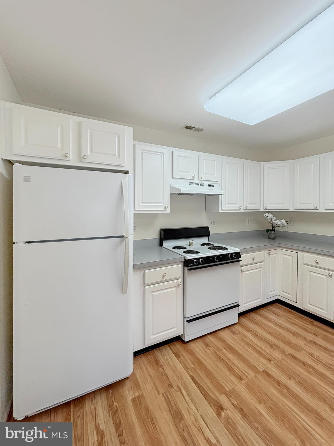 2023 Rudy Serra Drive, Unit 2D Eldersburg, MD 21784 - Photo 5 of 25 a kitchen with stainless steel appliances granite countertop a refrigerator sink and white cabinets