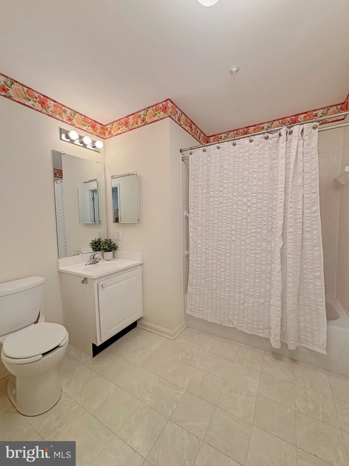 2023 Rudy Serra Drive, Unit 2D Eldersburg, MD 21784 - Photo 10 of 25 a bathroom with a sink toilet a mirror and shower