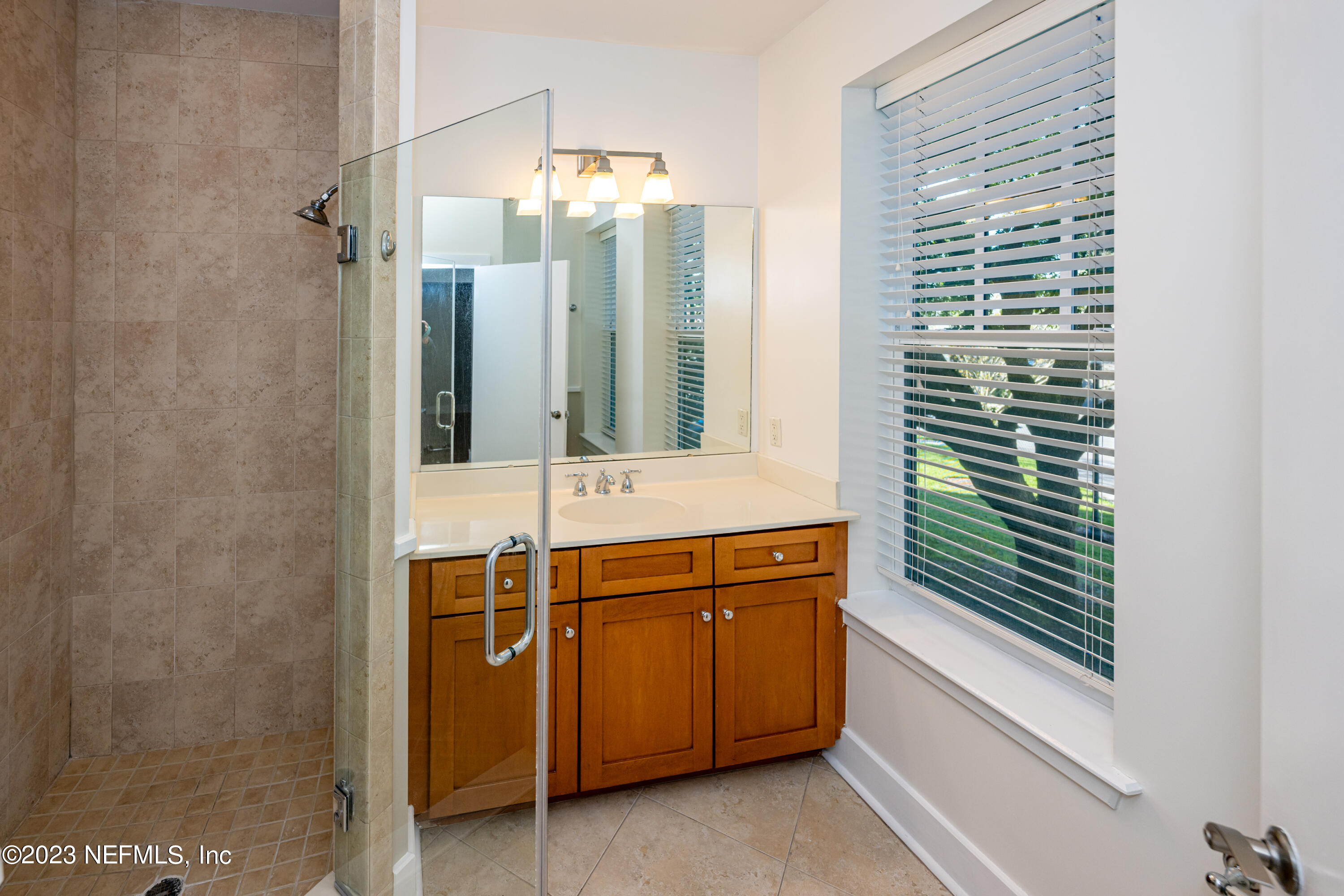 1661 Riverside Avenue, Unit 119 Jacksonville, FL 32204 - Photo 25 of 45 a bathroom with a sink a mirror and a shower