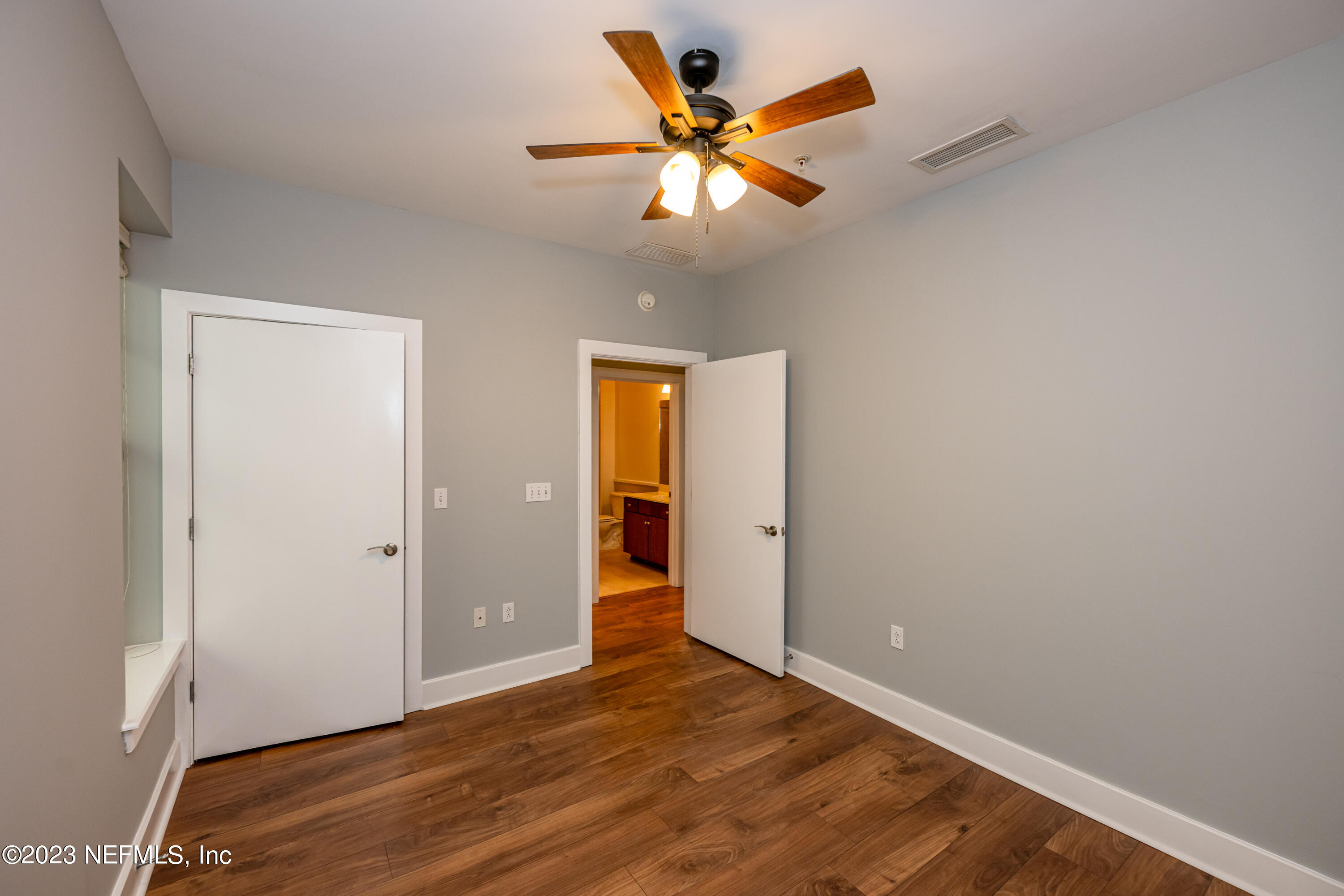 1661 Riverside Avenue, Unit 119 Jacksonville, FL 32204 - Photo 30 of 45 an empty room with wooden floor and a ceiling fan