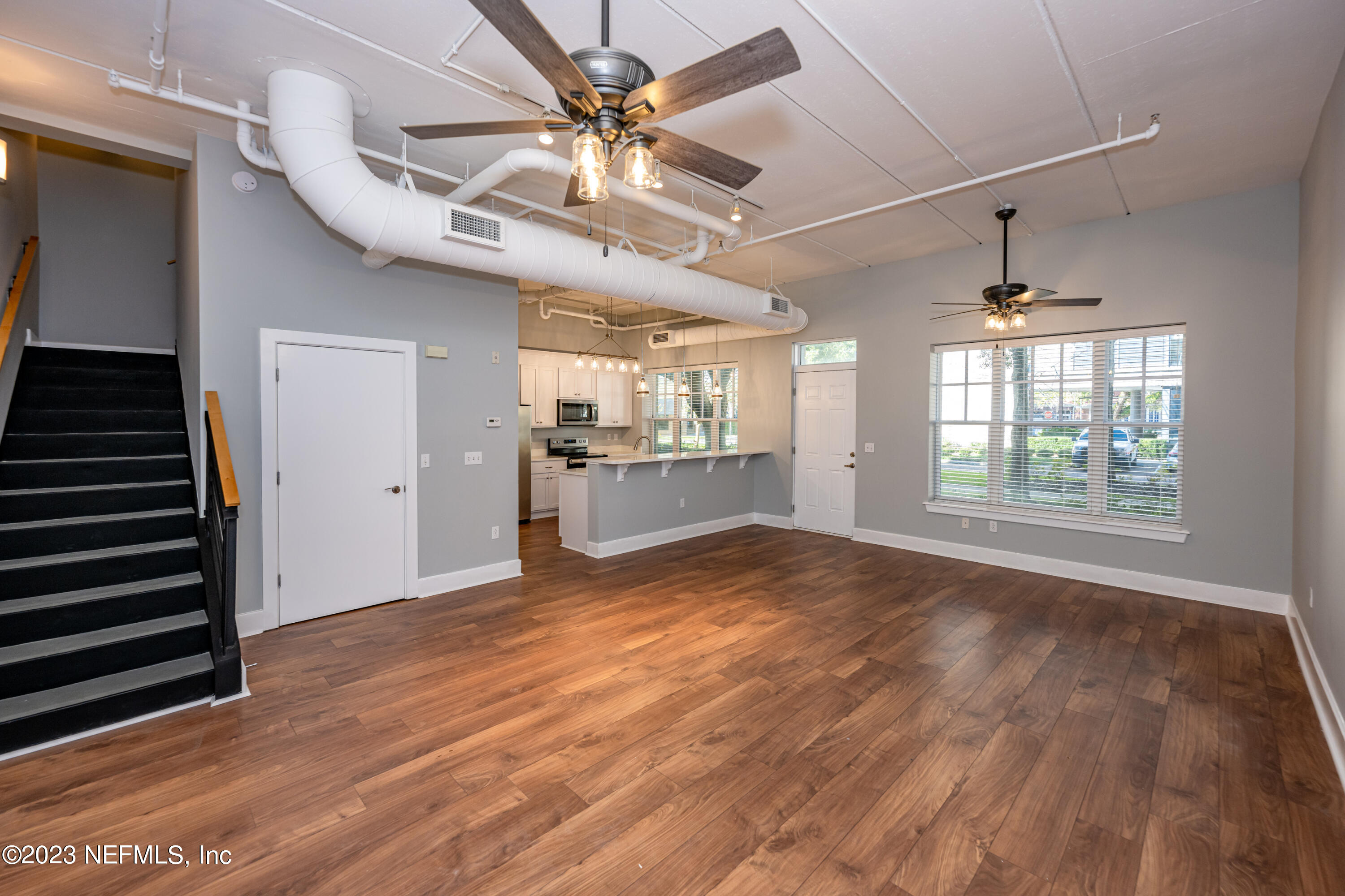 1661 Riverside Avenue, Unit 119 Jacksonville, FL 32204 - Photo 8 of 45 an empty room with wooden floor a ceiling fan and windows