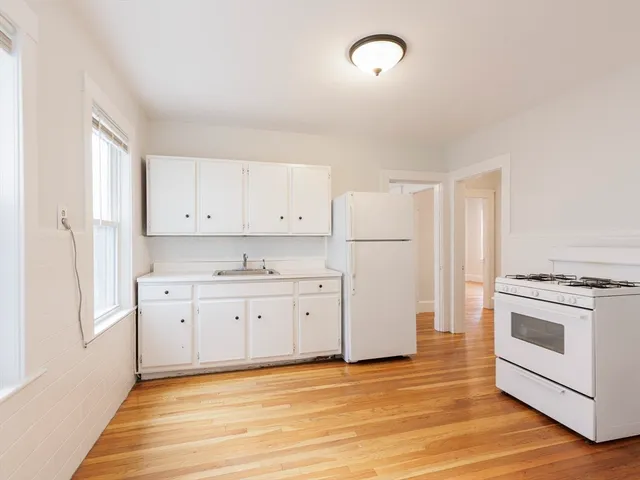 a kitchen with granite countertop white cabinets and white appliances
