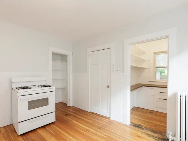 a view of a kitchen with wooden floor and electronic appliances