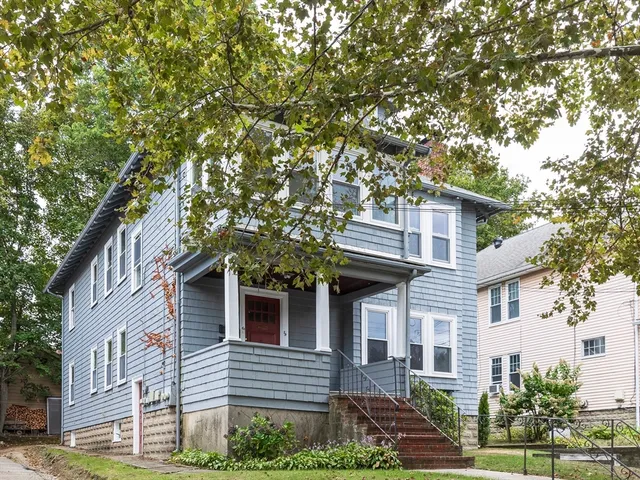 a front view of a house with plants