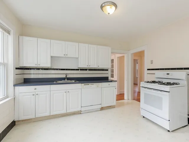 a kitchen with granite countertop white cabinets and white appliances