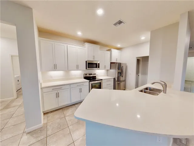 a kitchen with appliances a sink and cabinets