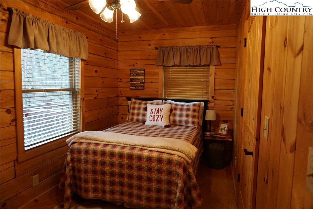 182 Buckland Road Grassy Creek, NC 28631 - Photo 15 of 38 a bedroom with a bed and wooden floor