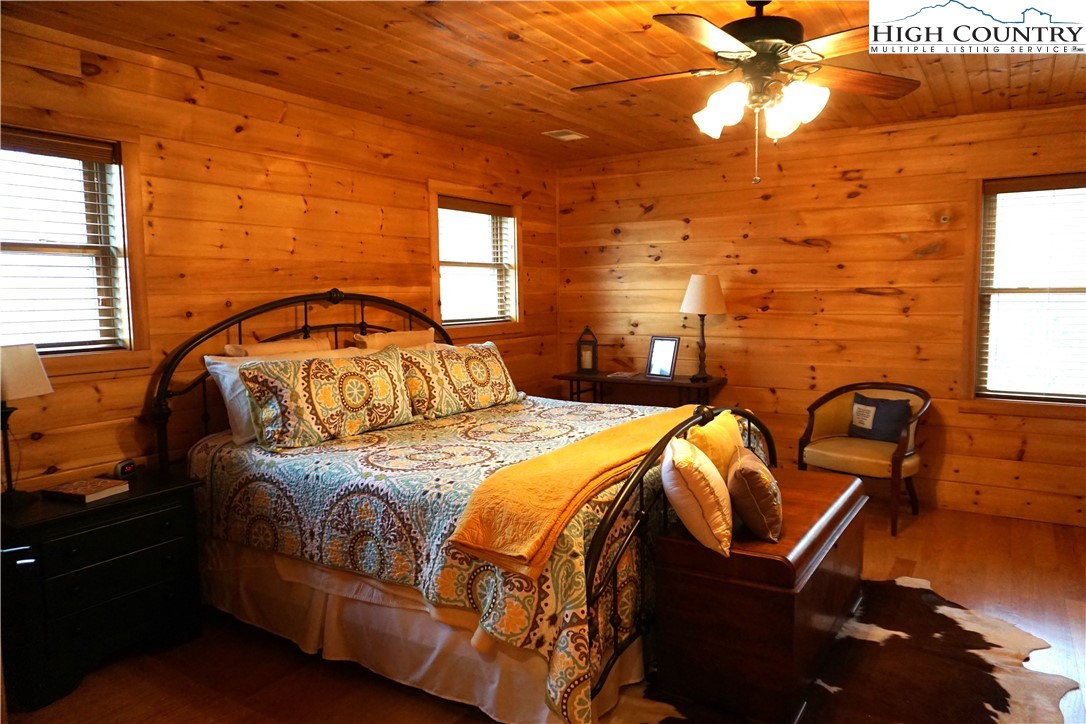 182 Buckland Road Grassy Creek, NC 28631 - Photo 17 of 38 a bedroom with a bed and wooden floor