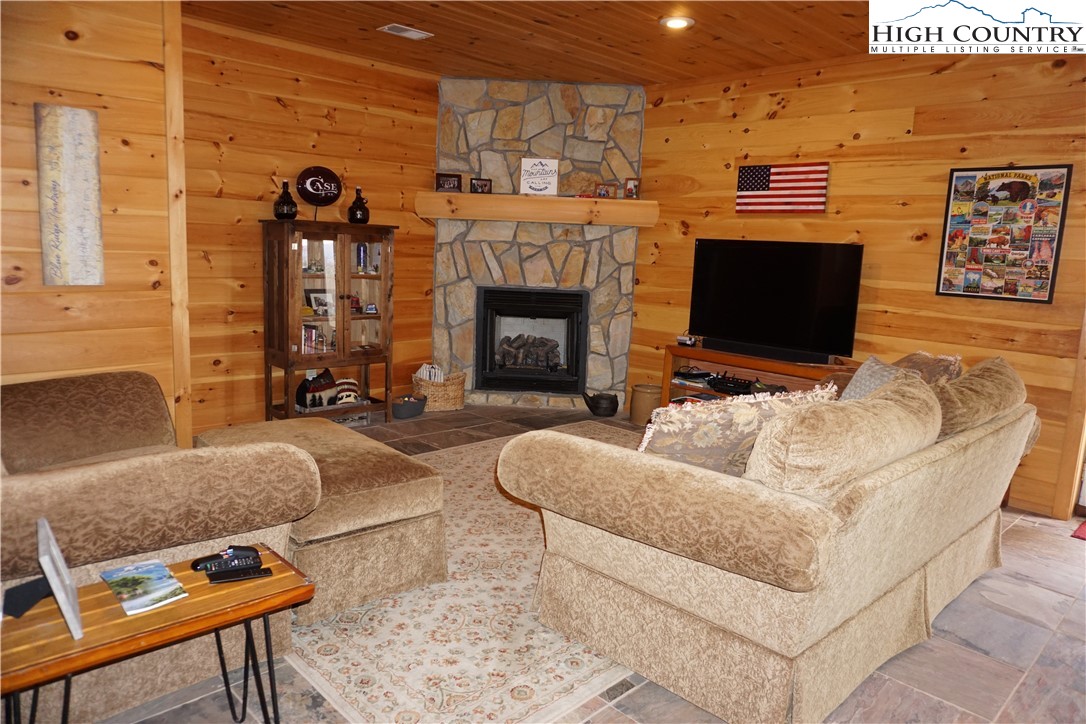 182 Buckland Road Grassy Creek, NC 28631 - Photo 22 of 38 a living room with furniture a flat screen tv and a fireplace