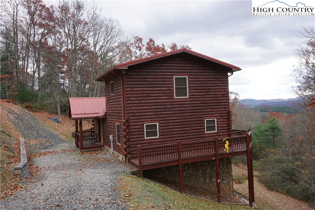 182 Buckland Road Grassy Creek, NC 28631 - Photo 29 of 38 a red brick house with a small yard and large trees