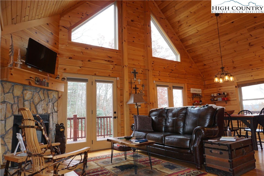 182 Buckland Road Grassy Creek, NC 28631 - Photo 5 of 38 a living room with furniture a flat screen tv and a floor to ceiling window