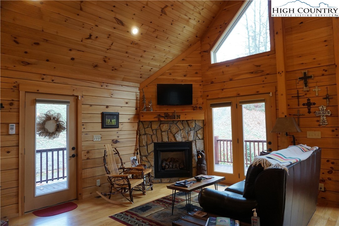 182 Buckland Road Grassy Creek, NC 28631 - Photo 6 of 38 a living room with furniture a flat screen tv and a fireplace