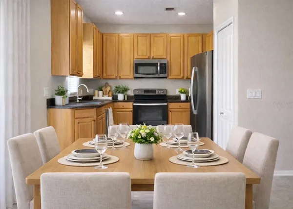 a kitchen with stainless steel appliances kitchen island granite countertop a dining table and chairs