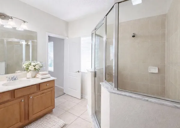 a bathroom with a granite countertop sink a mirror and a shower