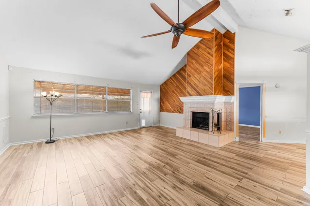 a view of empty room with wooden floor and fireplace