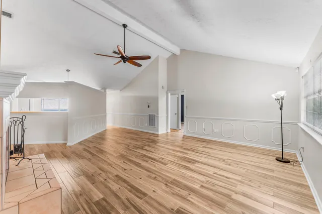 a view of empty room with wooden floor