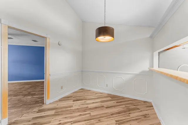 a view of a kitchen with wooden floor and a window