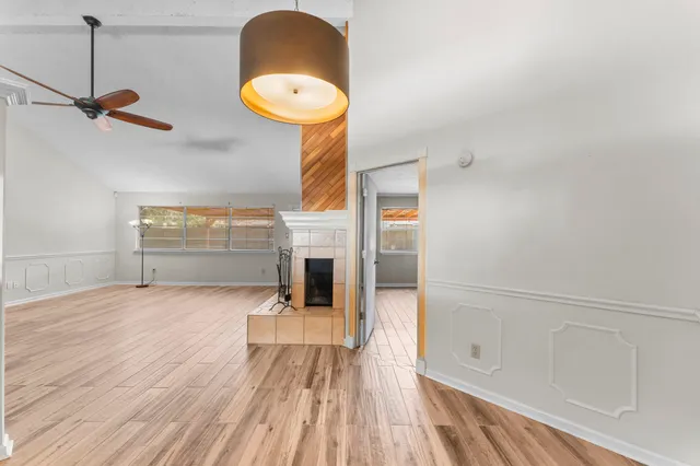 a view of empty room with a window and wooden floor