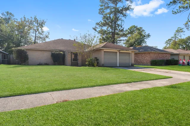 a view of a house next to a yard with large trees