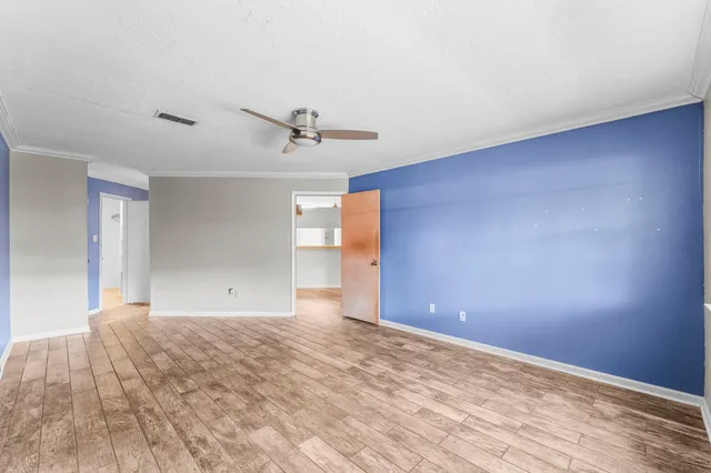 a view of empty room with wooden floor