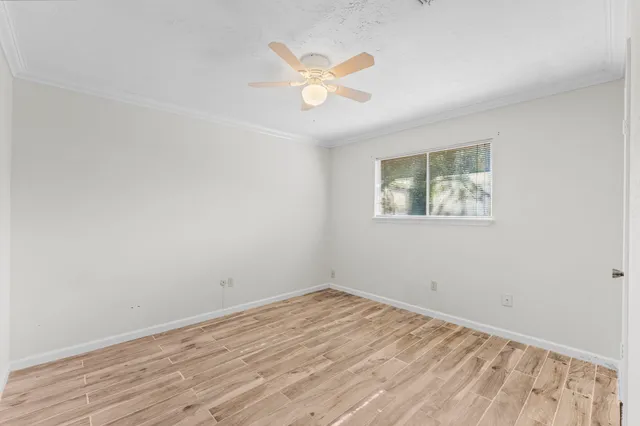 a view of a room with wooden floor and a ceiling fan