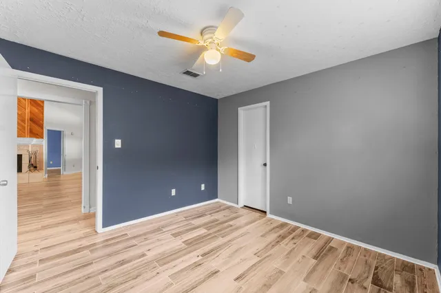 wooden floor in an empty room with a fan