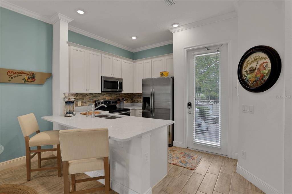 3083 Key Lime Loop Kissimmee, FL 34747 - Photo 16 of 82 a kitchen with stainless steel appliances granite countertop a refrigerator a stove a microwave oven with a dining table and chairs