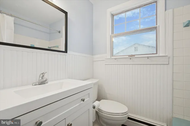 a bathroom with a sink mirror vanity and toilet