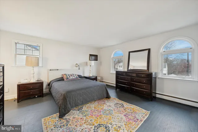 a bedroom with a bed and a dresser with chair