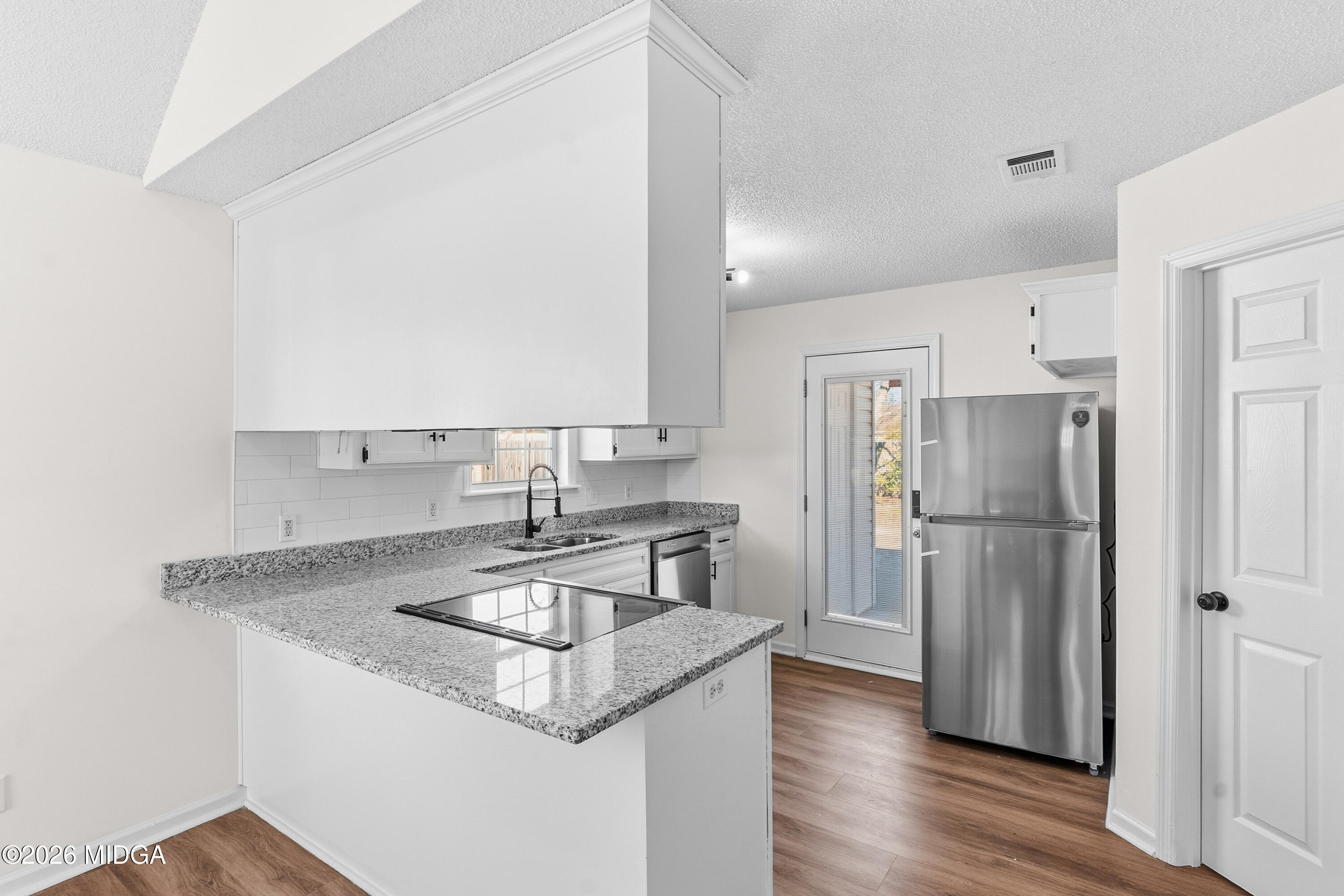 404 Wynfield Lane Bonaire, GA 31005 - Photo 12 of 45 a kitchen with stainless steel appliances granite countertop a refrigerator a sink a stove a dining table and chairs