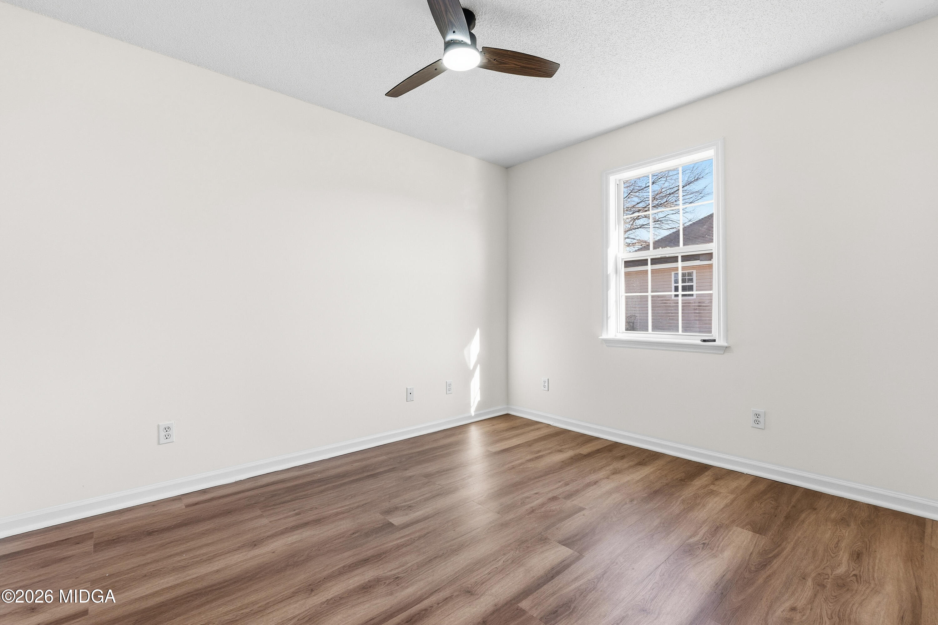 404 Wynfield Lane Bonaire, GA 31005 - Photo 27 of 45 an empty room with wooden floor chandelier fan and windows