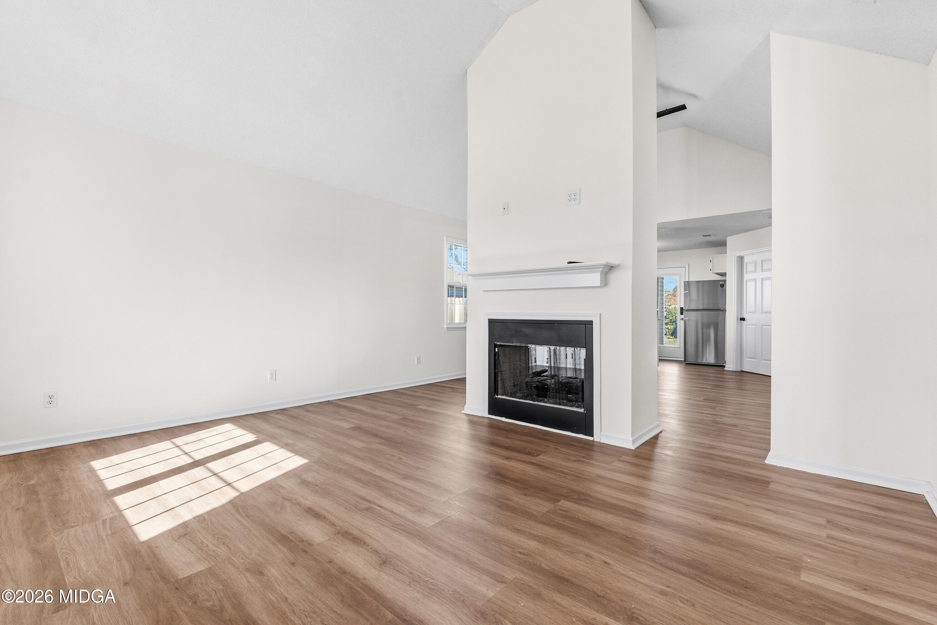 404 Wynfield Lane Bonaire, GA 31005 - Photo 3 of 45 an empty room with wooden floor and fireplace