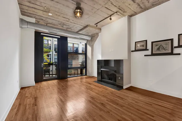 a view of an empty room with a fireplace and a window