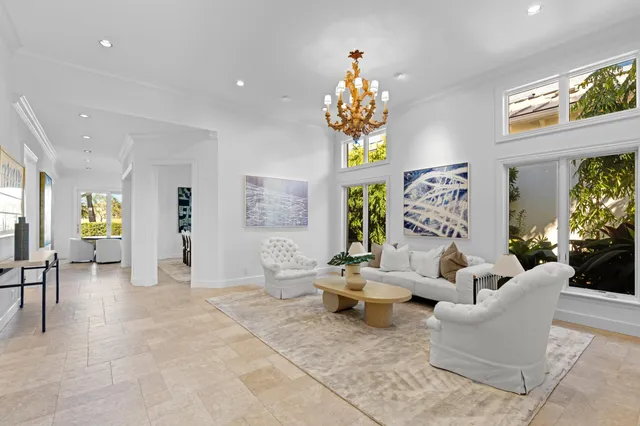 a living room with furniture a flat screen tv and a large window