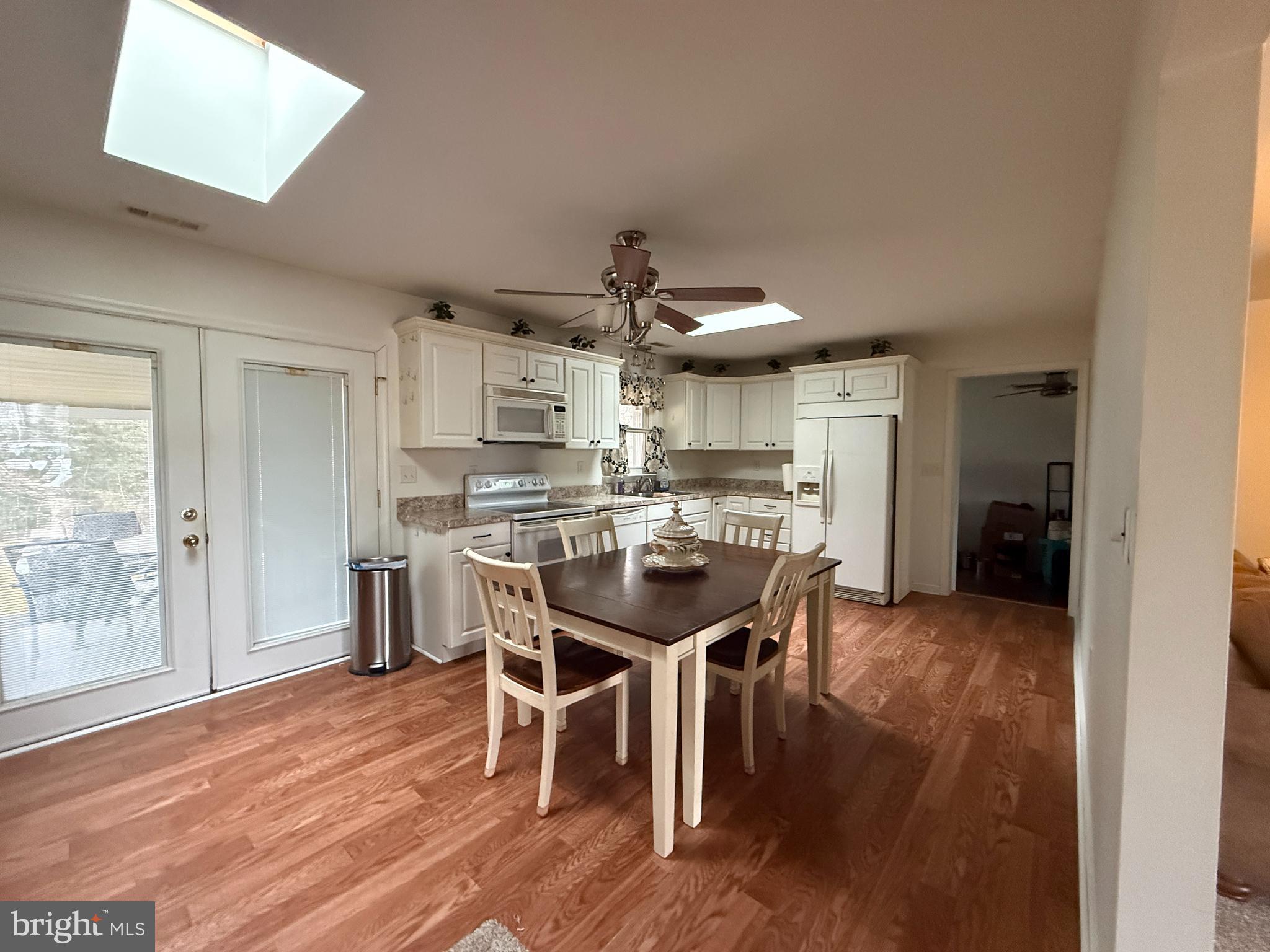 11305 River Road Ridgely, MD 21660 - Photo 13 of 14 a kitchen with stainless steel appliances a dining table chairs and wooden floor