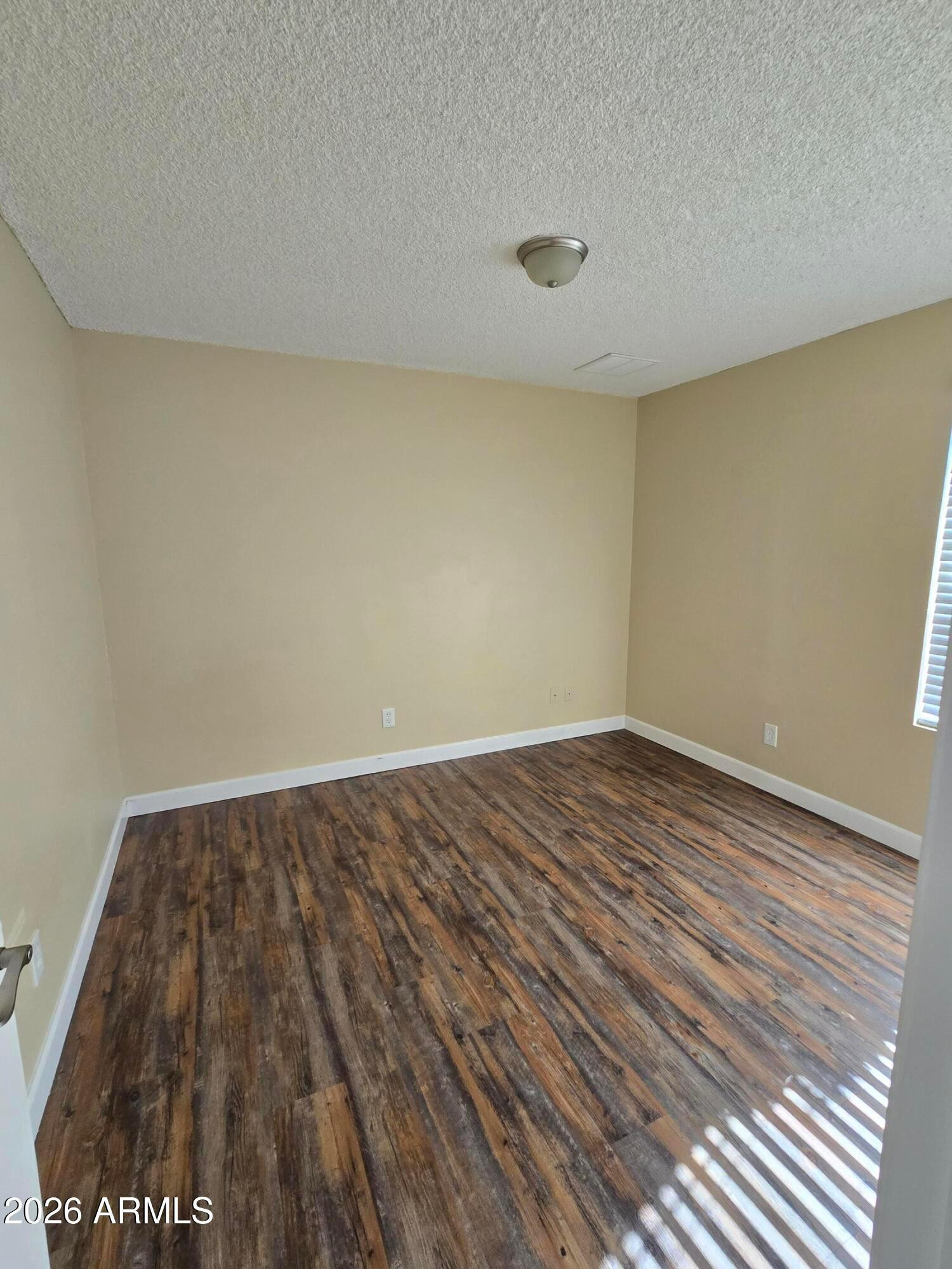 9002 West Roma Avenue Phoenix, AZ 85037 - Photo 15 of 29 a view of an empty room and wooden floor
