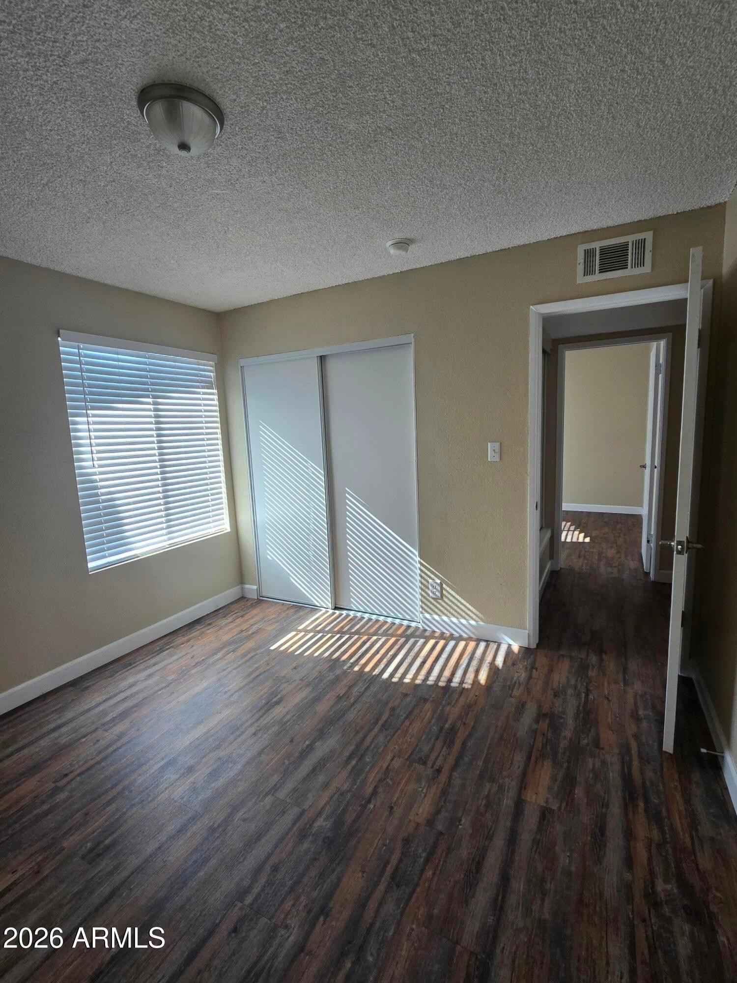 9002 West Roma Avenue Phoenix, AZ 85037 - Photo 16 of 29 a view of empty room with wooden floor