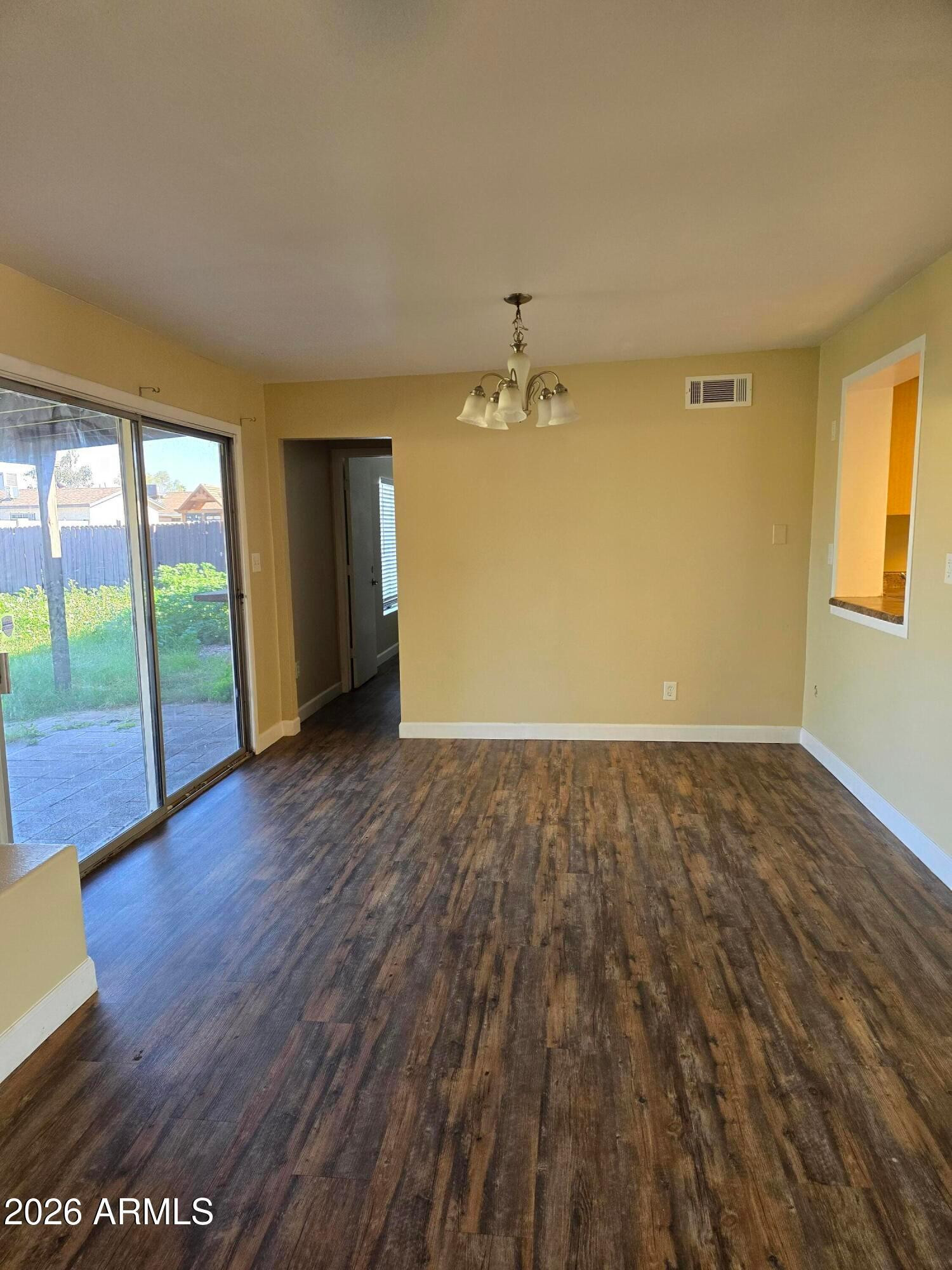 9002 West Roma Avenue Phoenix, AZ 85037 - Photo 17 of 29 an empty room with wooden floor and windows