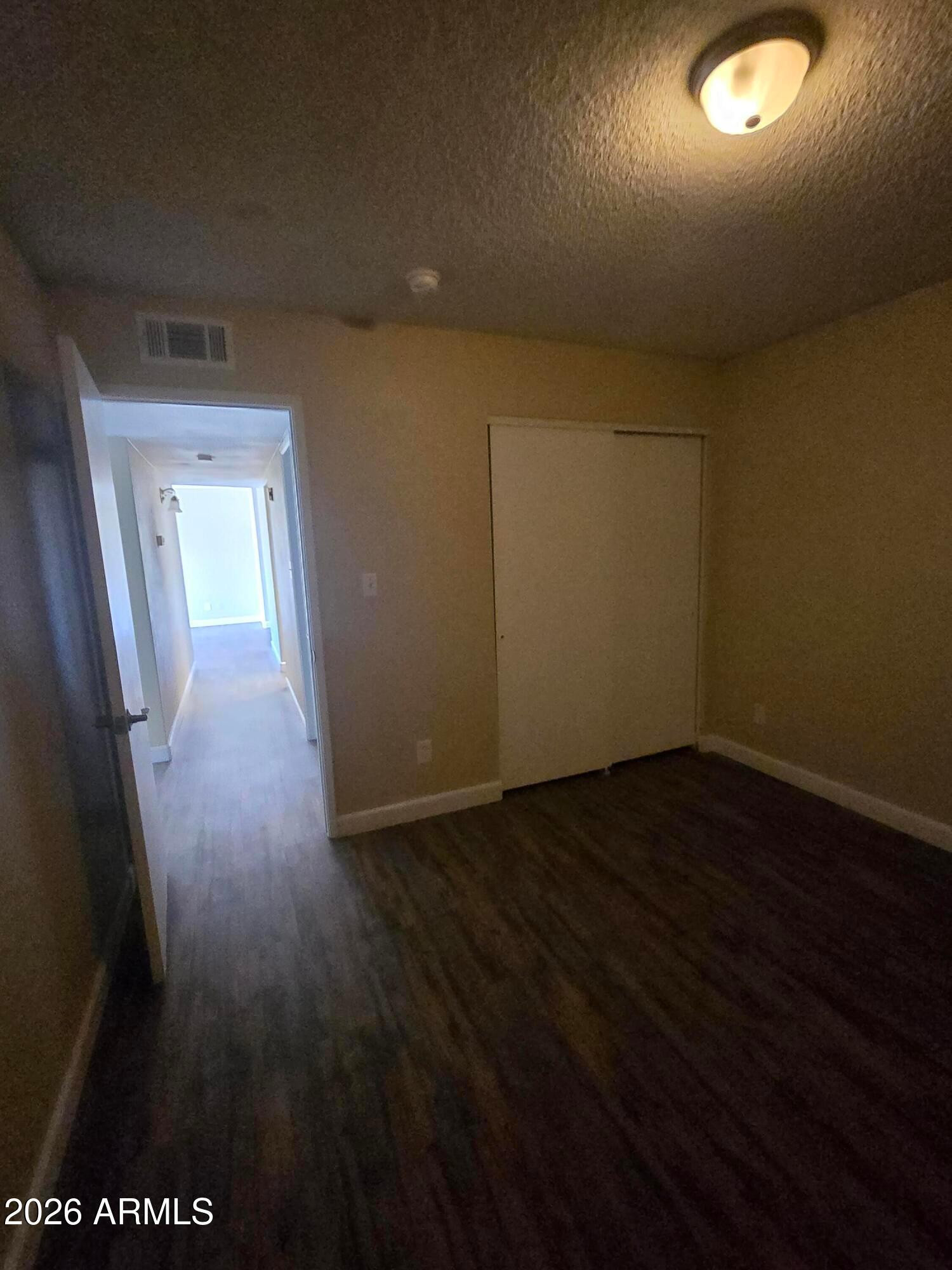 9002 West Roma Avenue Phoenix, AZ 85037 - Photo 22 of 29 a view of a hallway with wooden floor