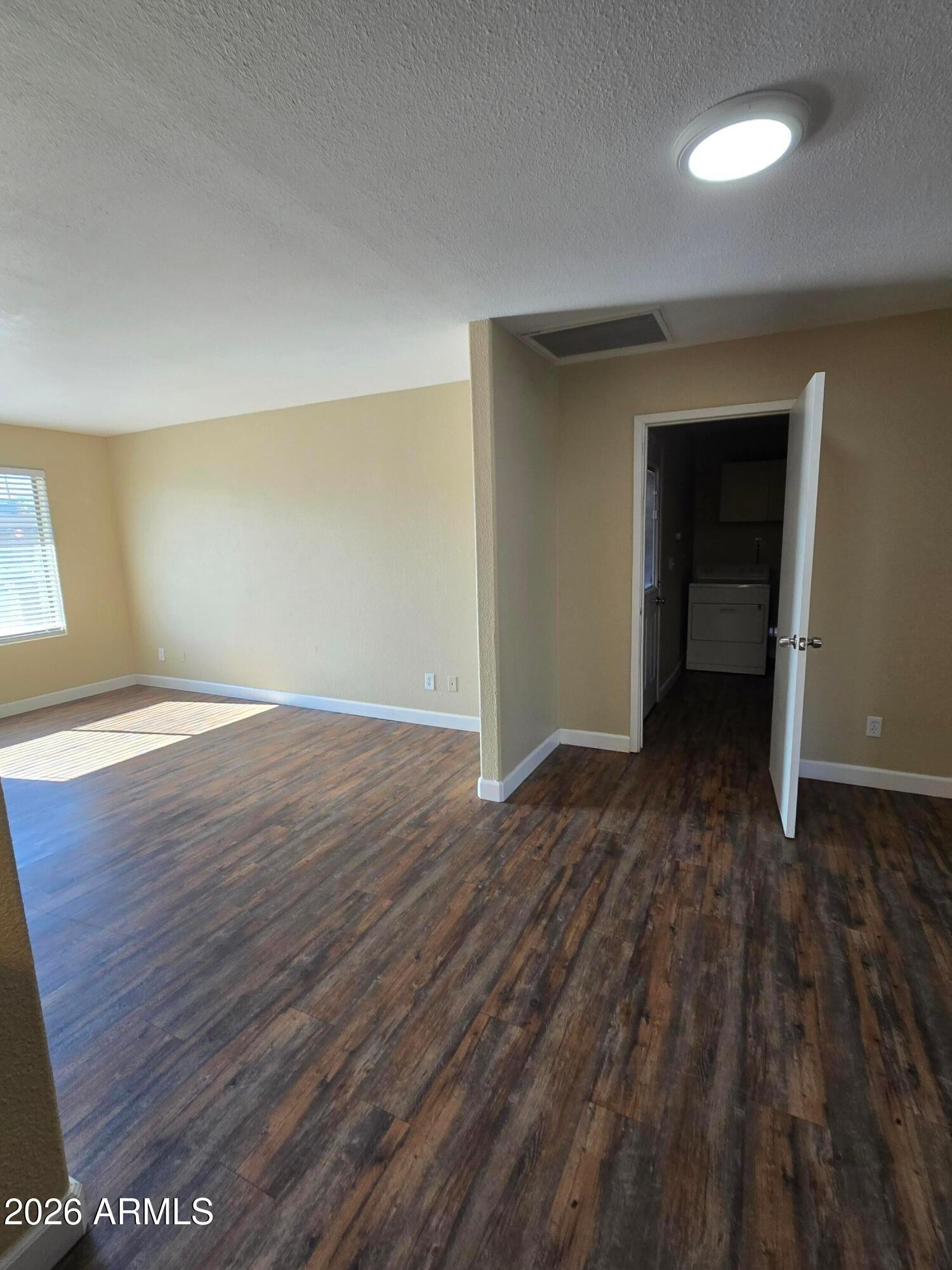 9002 West Roma Avenue Phoenix, AZ 85037 - Photo 4 of 29 wooden floor in an empty room with a window
