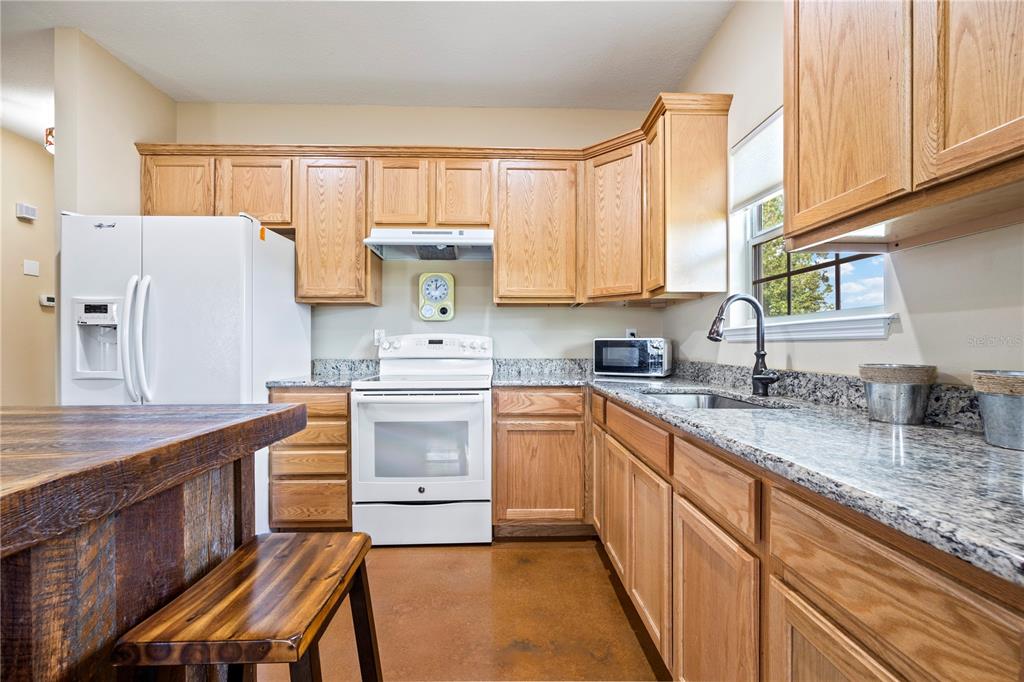 168 Southwest Poberezny Glen Lake Lake City, FL 32025 - Photo 14 of 29 a kitchen with granite countertop a sink stove and cabinets
