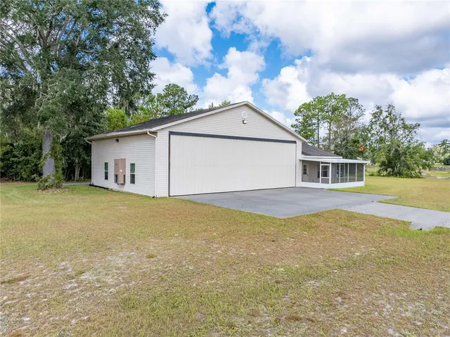a front view of house with yard and trees in the background