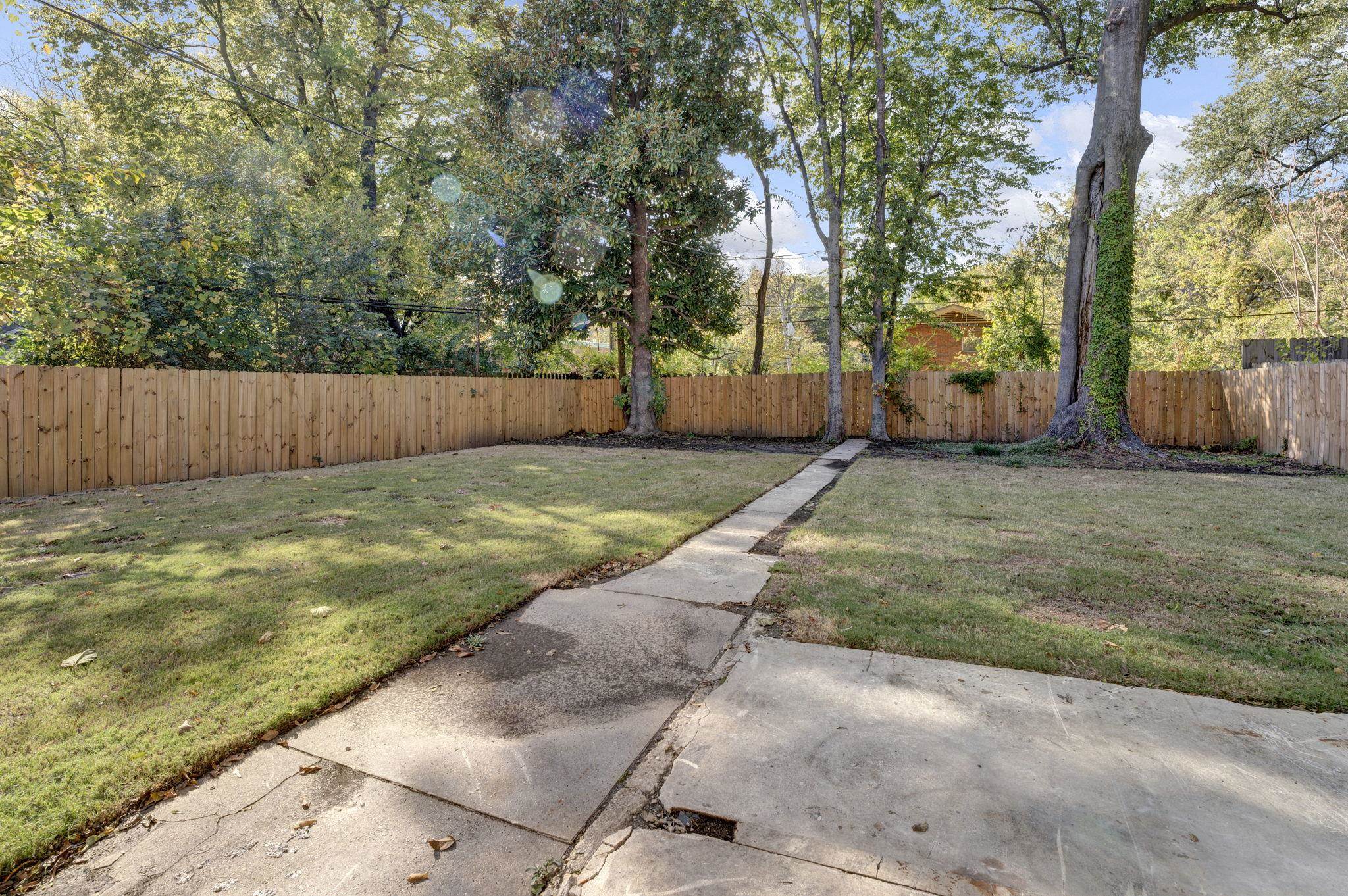 71 Clark Place Memphis, TN 38104 - Photo 10 of 11 a view of a backyard with large tree and wooden fence
