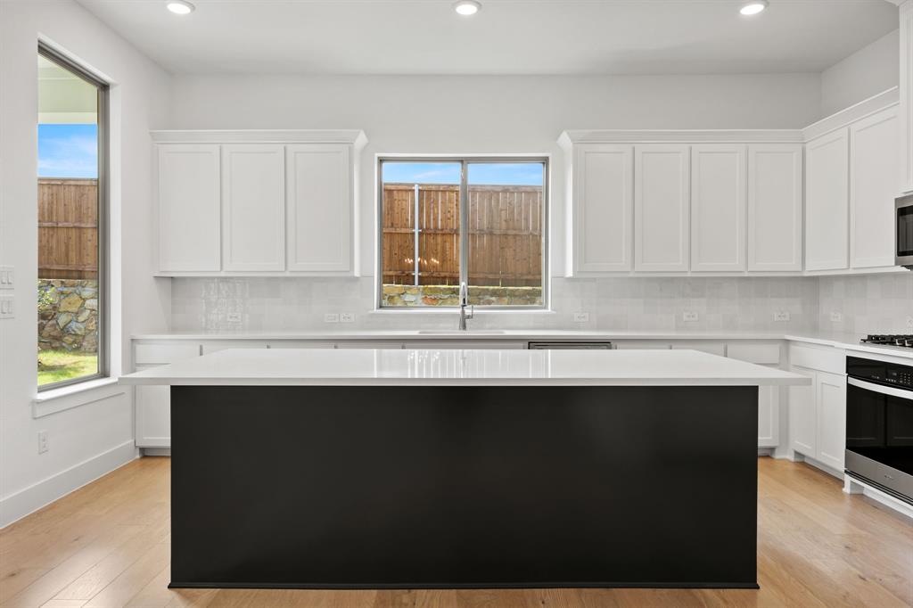 316 Chestnut Street Celina, TX 75009 - Photo 8 of 25 a kitchen with granite countertop a sink window and cabinets