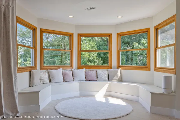 a view of an empty room with furniture and a window