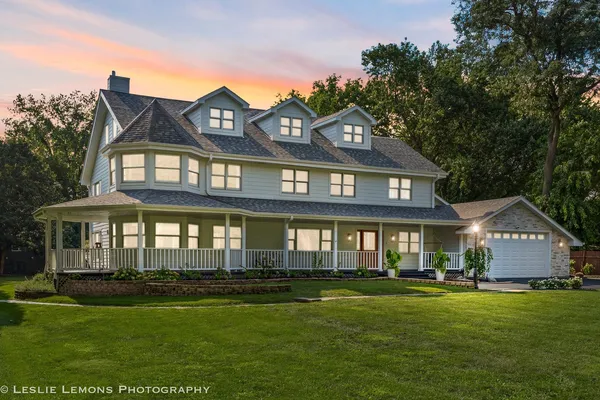 an aerial view of residential building with outdoor space and trees all around