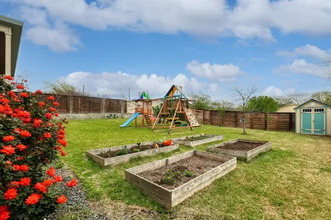 a view of a white house with a big yard and potted plants